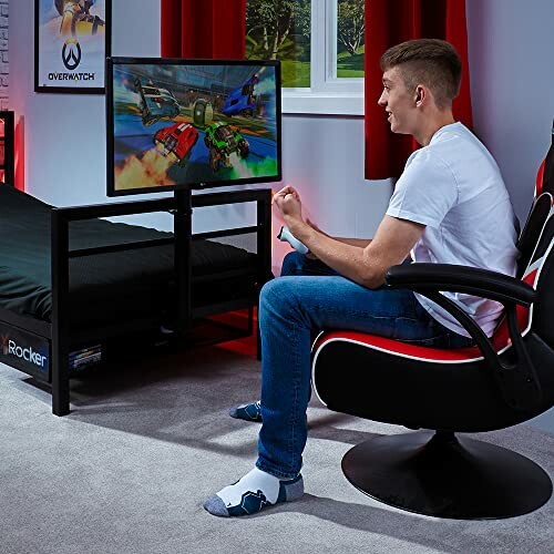 Person playing video game on a screen in a bedroom setup.